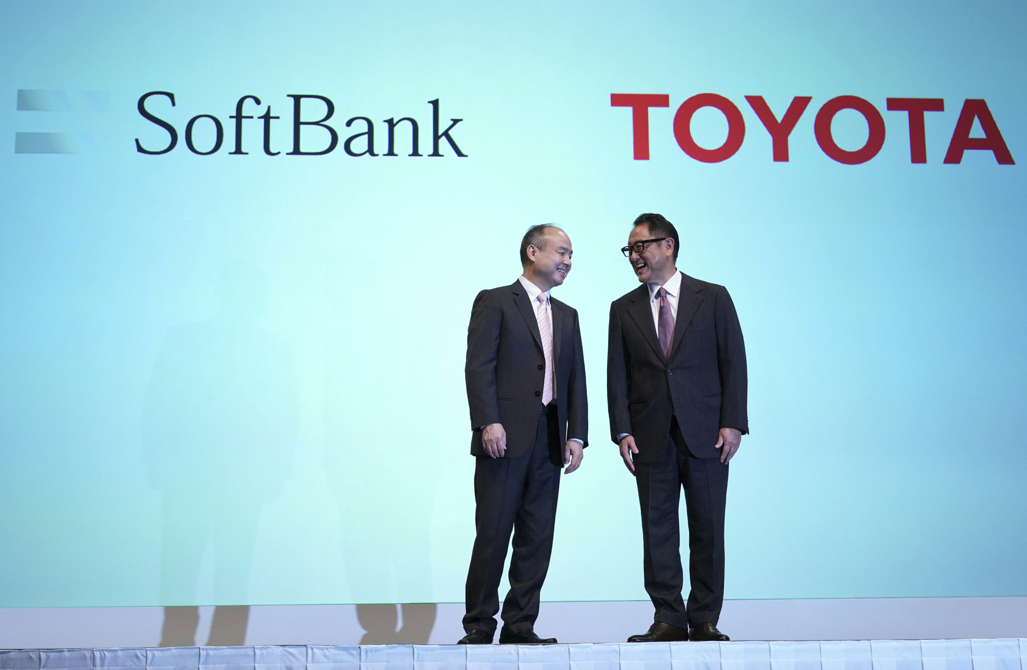 Softbank Group Corp. Chairman Masayoshi Son, left, and Akio Toyoda, right, President of Toyota Motor Corporation chat during a photo session during a press conference in Tokyo Thursday, Oct. 4, 2018. Japan窶冱 No. 1 automaker Toyota Motor Corp. and technology giant SoftBank Group Corp. say they are setting up a joint venture to create mobility services. (AP Photo/Eugene Hoshiko)